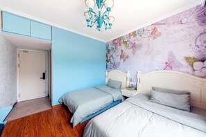 A bedroom with two beds, a blue wall, a floral mural, and a ceiling light. - Shengsi Yajing Homestay (Shengsi)
