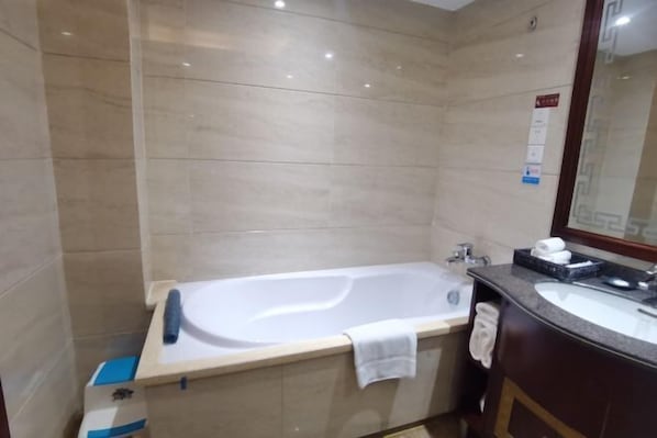 A modern bathroom with a freestanding bathtub, a sink, and a mirror. - Guilin Yi Hotel (Guilin Station) (Guilin)