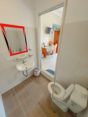 A bathroom with a sink, mirror, toilet, and a glass shower enclosure. - HOA LAN HOTEL (Xuan Huong - Da Lat)