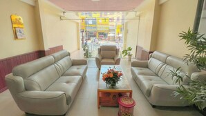 A lobby with two sofas, a coffee table with flowers, and a chair. - HOA LAN HOTEL (Xuan Huong - Da Lat)
