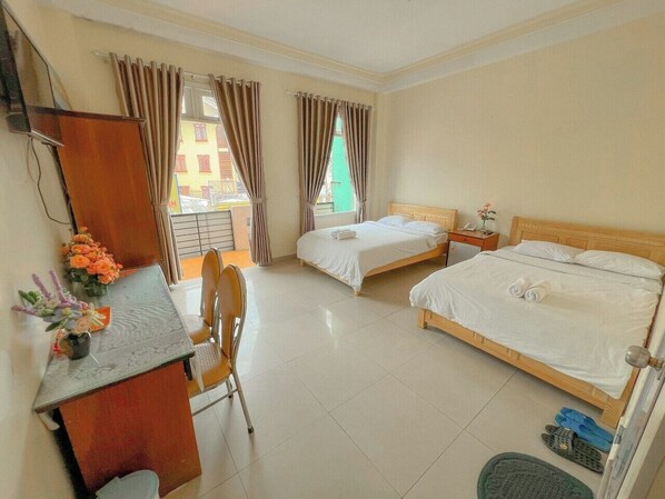 Une chambre d’hôtel avec deux lits, un bureau et une chaise.