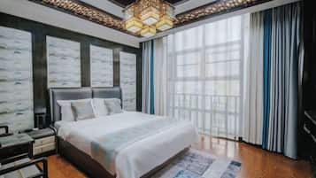 Un dormitorio con una cama grande, una mesita de noche, un aparador y una ventana con cortinas.