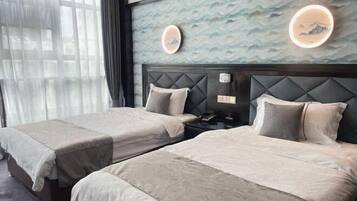 A hotel room with two beds, a nightstand, and a wall with decorative elements.