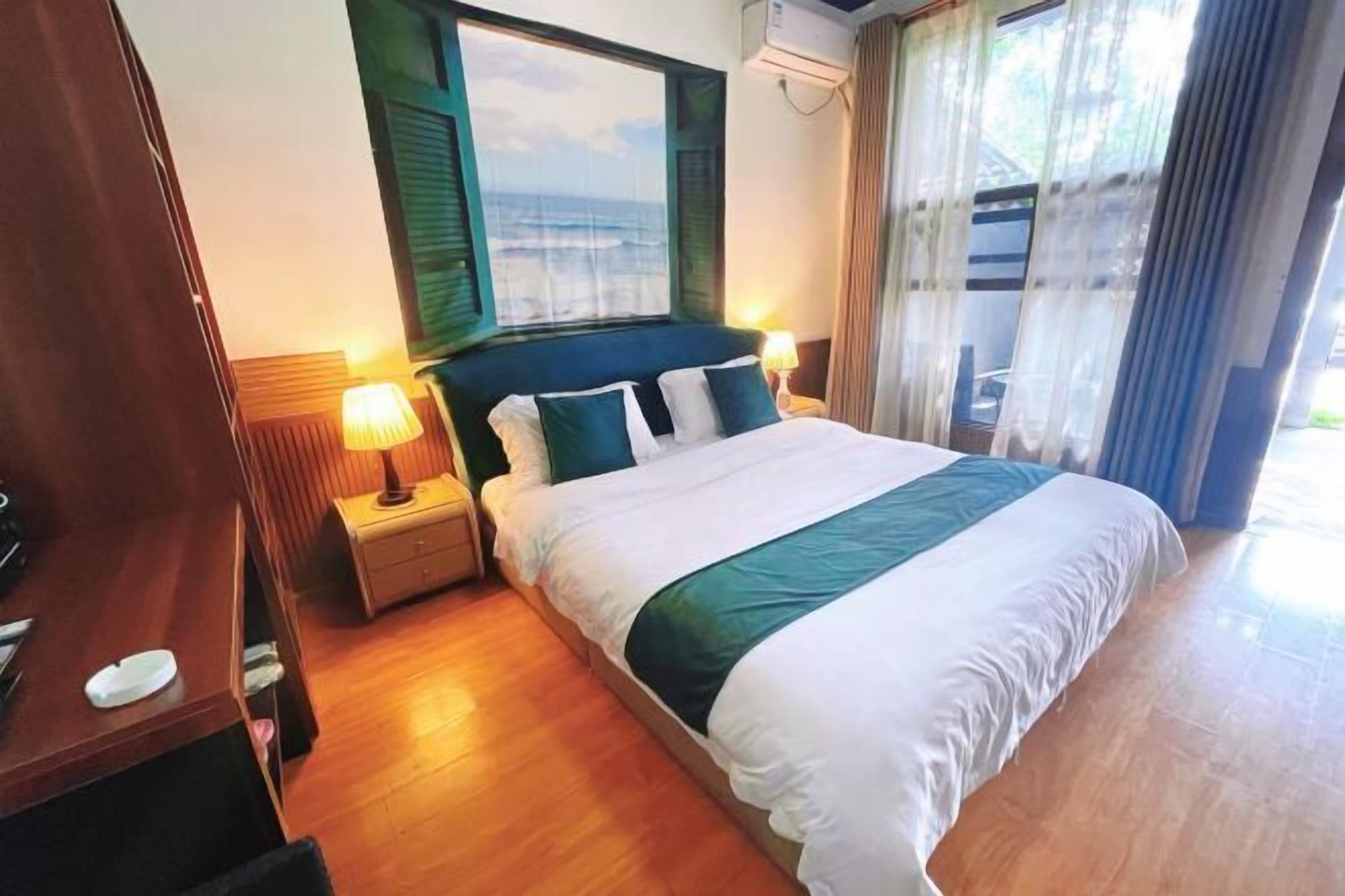 Quarto de hotel com cama, mesas de cabeceira, janela e cortinas.