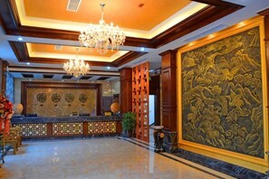 A lobby with a reception desk, chandeliers, and a large decorative wall. - TS Business Hotel (Meishan)