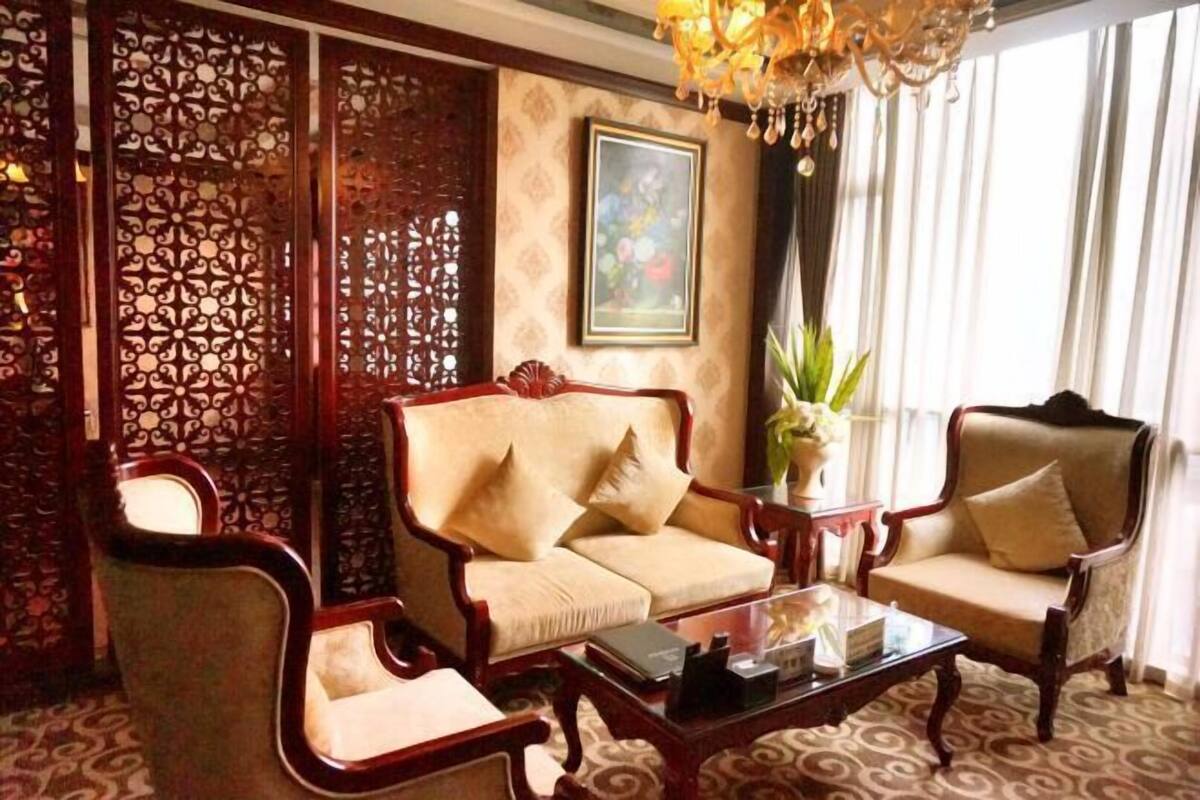 A traditional-style living room with a sofa, armchairs, a coffee table, and a decorative screen.