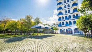 Un bâtiment doté de nombreux balcons et d’un espace extérieur couvert avec un sol à motifs.