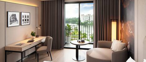 A hotel room with a bed, a desk, a chair, a small table with a plant, and a view of a cityscape through large windows.