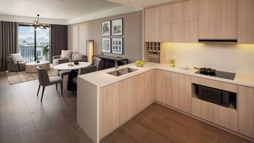 Een moderne keuken met een centraal eiland, een eetgedeelte met een ronde tafel, en een woonkamer met een bank en salontafel.