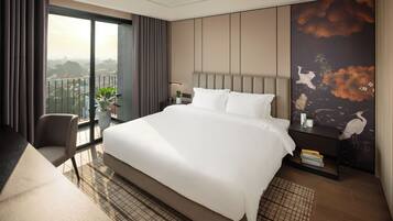 A modern hotel room with a large bed, a balcony with curtains, a desk, and a wall with a nature-themed mural.