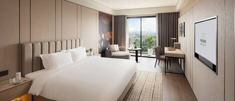 A modern hotel room with a large bed, a desk, and a view of the city.