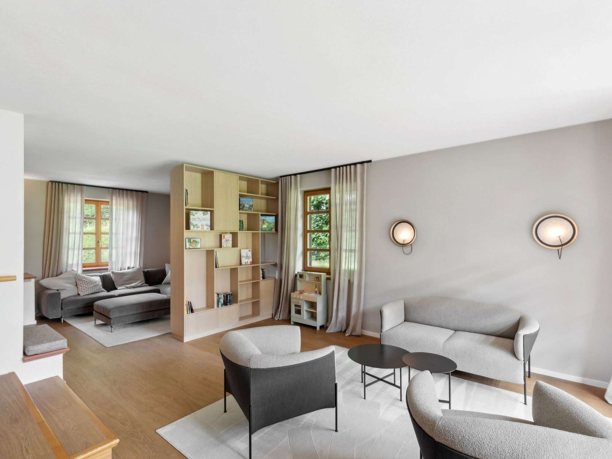 A modern living room with a sofa set, a coffee table, and a bookshelf.