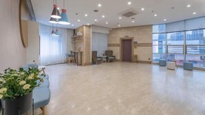 A spacious lobby with a modern design, featuring a seating area with sofas and a small table, a reception desk, and large windows offering a view of the cityscape. - Homeinn Hotel (Ningbo Tianyi Square Center) (Ningbo)