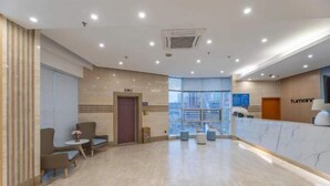A modern lobby with a reception desk, seating area, and a large window providing natural light. - Homeinn Hotel (Ningbo Tianyi Square Center) (Ningbo)