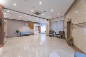 A spacious lobby with a reception desk, seating area, and a large mirror. - Homeinn Hotel (Ningbo Tianyi Square Center) (Ningbo)