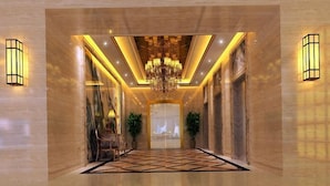 A spacious hallway with a geometric patterned floor, a grand chandelier, and wall-mounted lighting fixtures. - Yaduo Holiday Hotel (Zhongshan)
