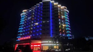 A multi-story hotel with a modern design, featuring balconies on each floor and a prominent entrance with illuminated signage. - Yaduo Holiday Hotel (Zhongshan)
