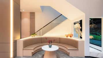 Un interior moderno con una zona de estar curvada, una mesa central y un ventanal grande.