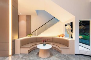 A modern interior with a curved seating area, a central table, and a large window. - Longfeng Hotel (Enping)