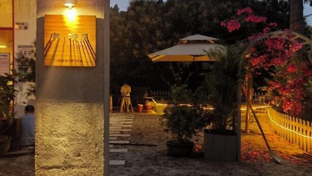 A courtyard with a stone pillar, a sign, potted plants, a pathway, and a fence. - XUQIANFENG (Shenzhen)
