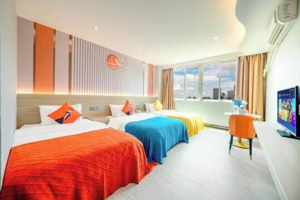 Hotelkamer met twee bedden, een televisie, een raam met uitzicht over de stad en een modern interieur.