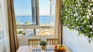 A dining area with a table, chairs, a potted plant, and a fruit bowl. - Boutique Sea view studio 2A - La Cala de Mijas (La Cala de Mijas)