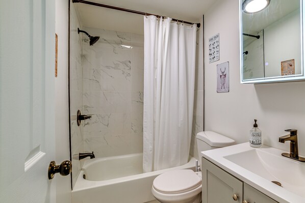Ein Badezimmer mit Badewanne, Toilette und Waschbecken.