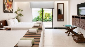 Une chambre d’hôtel avec un lit, un bureau, une télévision et une vue sur la verdure.