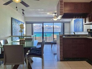 Enjoy meals in the kitchen with a central island, dining area, and ocean views through large glass doors.