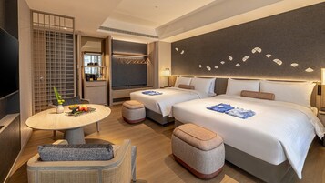 Een hotelkamer met twee bedden, een eethoek en een kitchenette.