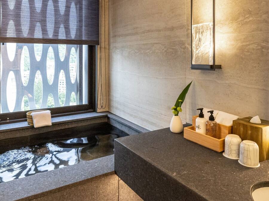 A modern bathroom with a freestanding bathtub, a wooden vanity, and a large mirror.