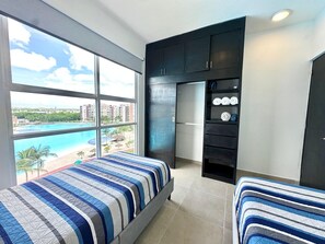 Enjoy a serene view of the pool from the large window in this stylish room, featuring a comfortable bed and modern amenities.
