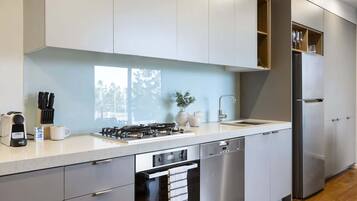 A modern kitchen with stainless steel appliances, a built-in oven, and a dishwasher.