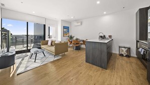 A modern apartment with a balcony, a dining area, a kitchen, and a living room. - Refined 2-Bed With Luxurious Building Amenities (Belconnen)