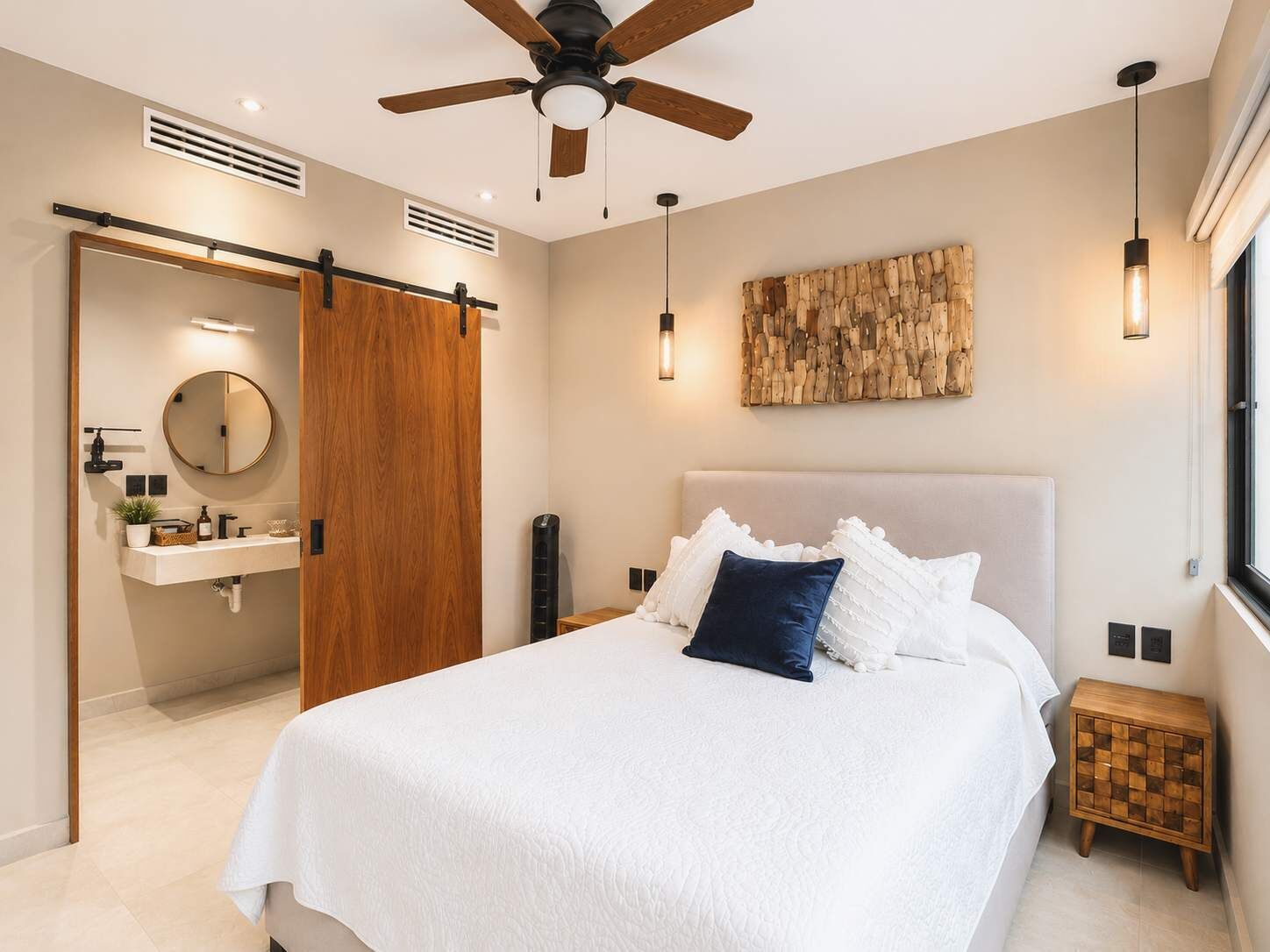 Una camera da letto con un letto, una ventola a soffitto, un lampadario a parete, un comodino e una finestra.