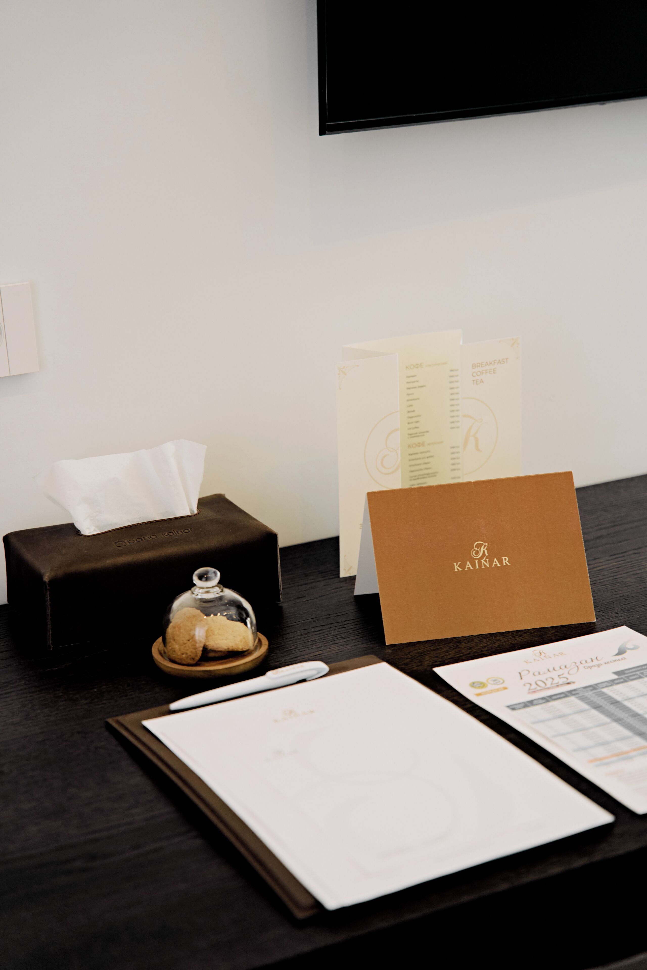 A hotel reception desk with a tissue box, a menu, a card, and a menu holder.