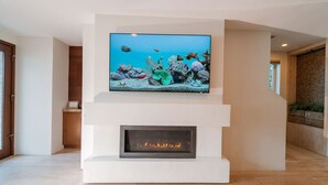 A modern living room with a flat-screen TV mounted above a fireplace. - 3 BR, Roof Deck, Ocean Views, Hot Tub, Beach Block (Newport Beach)