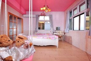 A bedroom with a bed, a chair, a swing, and two teddy bears.