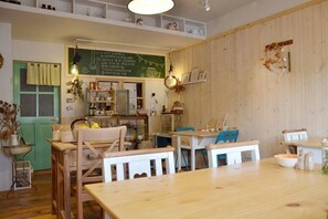 A cozy restaurant with wooden furniture, a chalkboard menu, and a green door. - Jiufen Sunnyrain-bed-and-breakfast (New Taipei City)