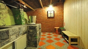 A rustic kitchen with a stone countertop, a brick wall, and a wooden bench. - Jiufen Sunnyrain-bed-and-breakfast (New Taipei City)
