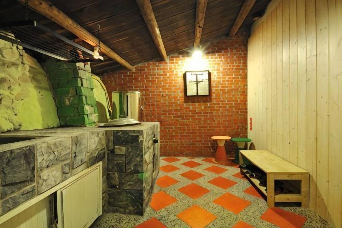 Eine rustikale Küche mit Steinschnittplatte, Backsteinwand und einer Holzbank.