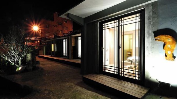 A modern building with large glass doors and a wooden deck leading to the entrance. - Jiufen Sunnyrain-bed-and-breakfast (New Taipei City)