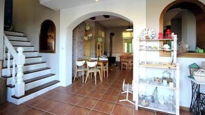 A spacious living area with a staircase, a dining table, and a kitchen area with shelves. - Jiufen Sunnyrain-bed-and-breakfast (New Taipei City)