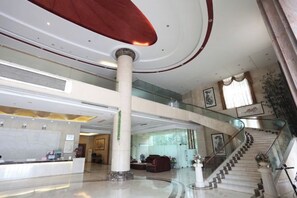 A spacious lobby with a reception desk, a staircase, and a high ceiling. - Xinghe Hotel(Dongguan Humen road east) (Dongguan)