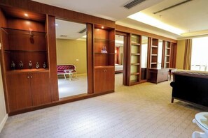 A hotel room with a large wardrobe, a bed, and a dining area. - Xinghe Hotel(Dongguan Humen road east) (Dongguan)