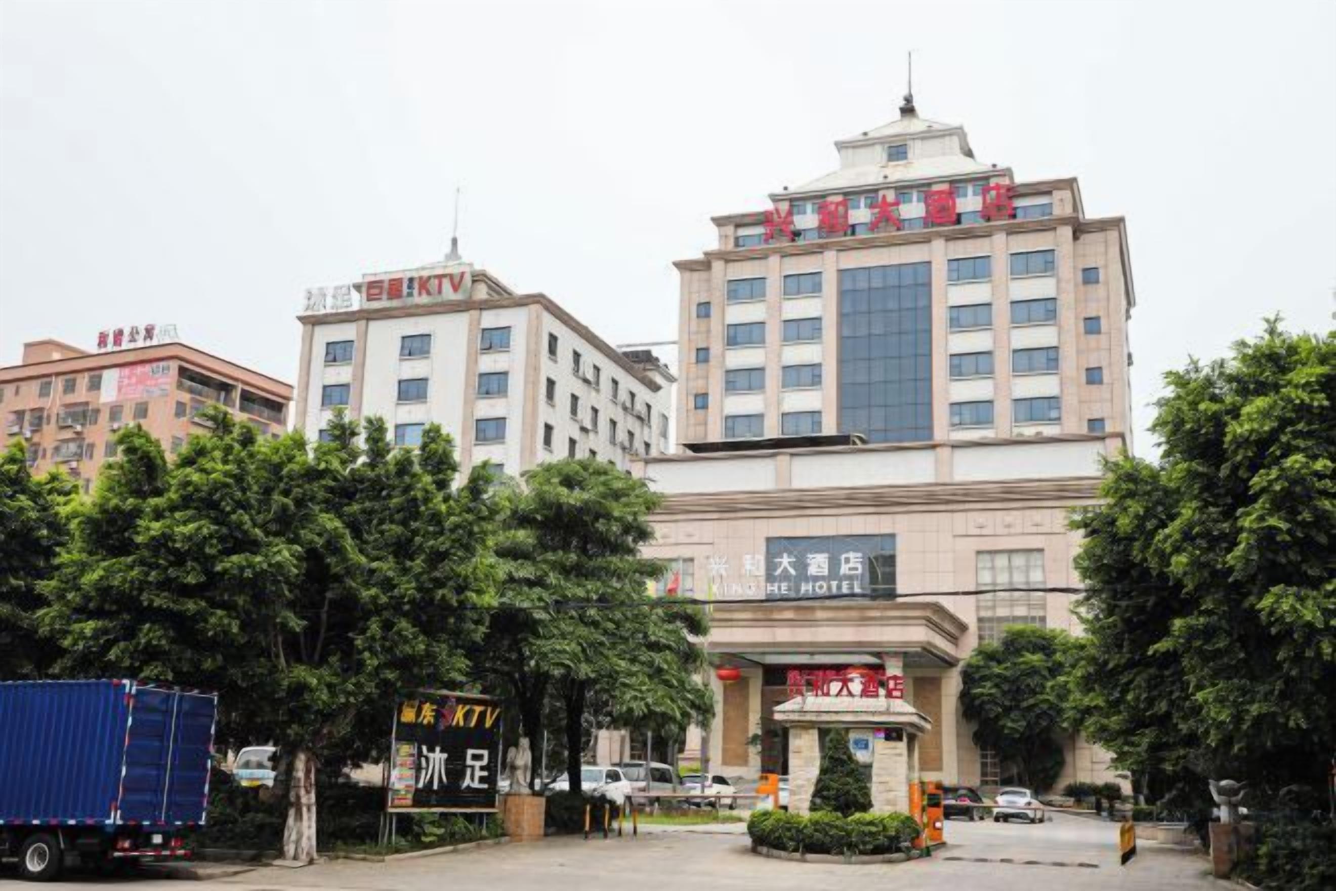 A hotel with a large entrance, multiple floors, and a prominent sign.