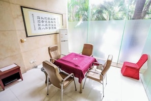 Enjoy a meeting or dining space with a large window offering a view of palm trees and a table for six.