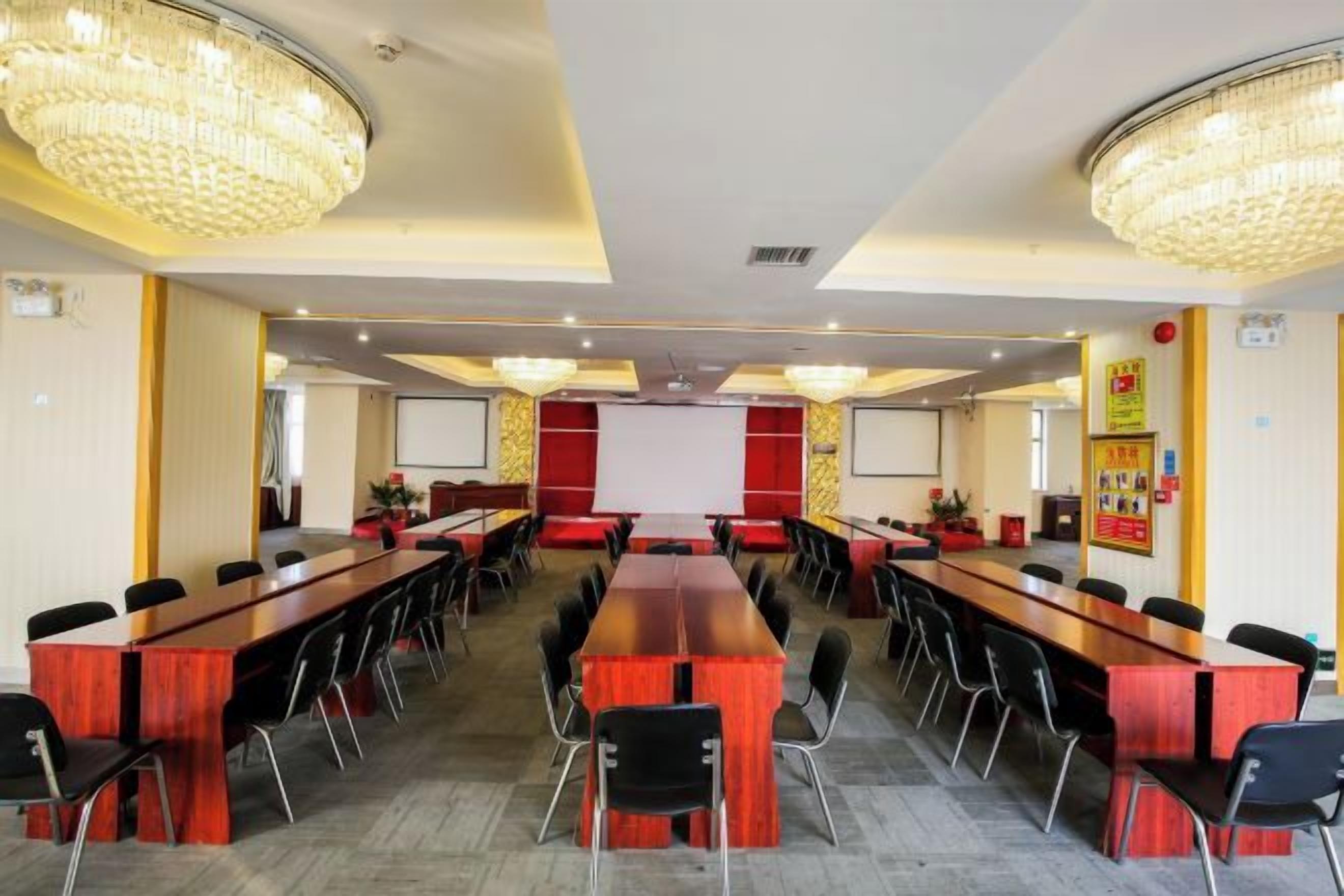 A conference room with a long table, multiple chairs, and a projector screen.