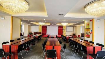 A conference room with a long table, multiple chairs, and a projector screen.