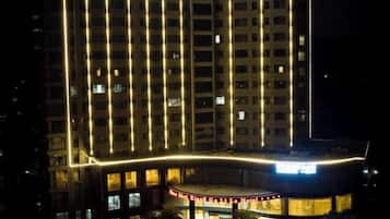 A multi-story hotel with a curved entrance and illuminated windows.